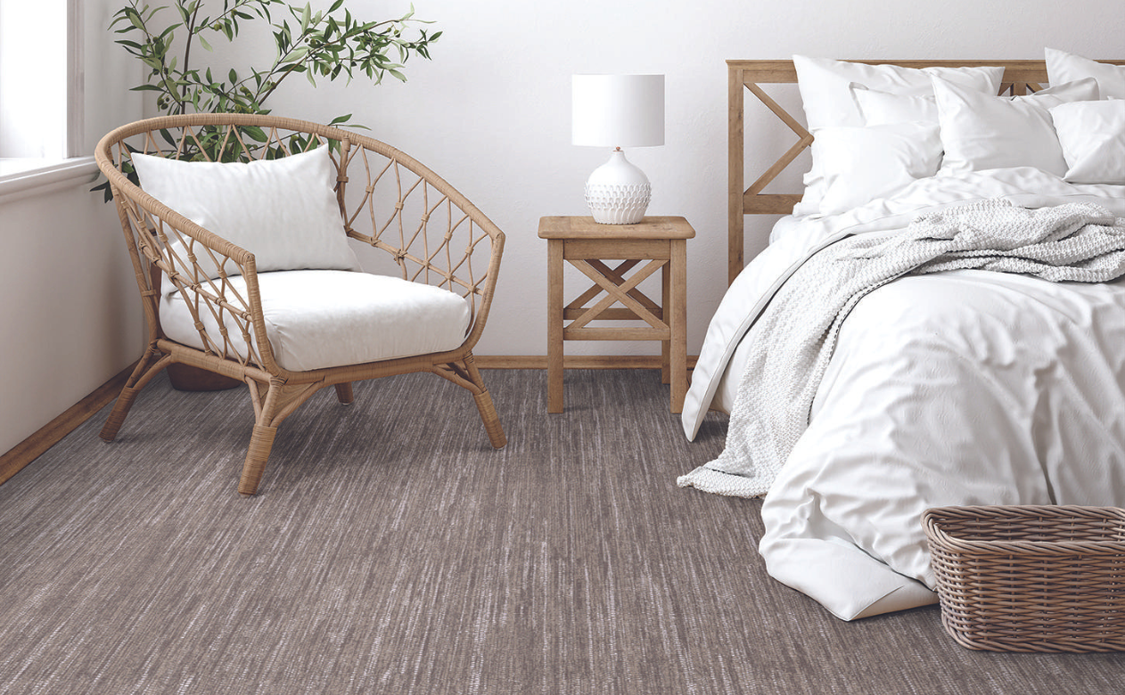 neutral grey carpet in bedroom with rattan boho furniture